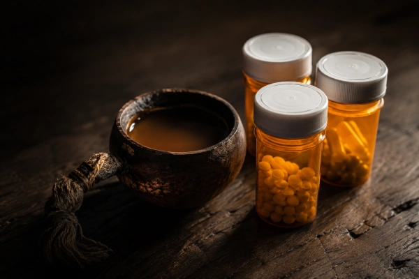 Prescription medications beside an ayahuasca cup, interaction risk